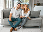 Portrait of happy parents and their little son at home. Adorable caucasian boy smiling and standing with an arm around his mother and father. Young parents enjoying free time with their son on weekend