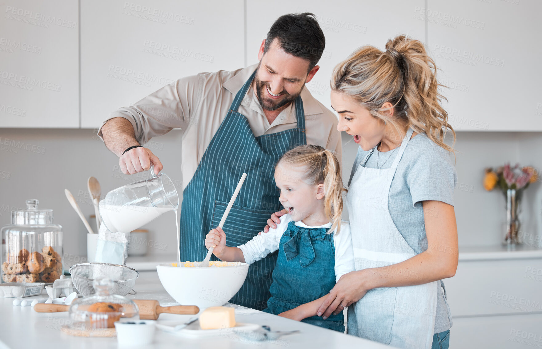 Buy stock photo Kitchen baking, family and learning kid cooking, happy and help prepare milk, flour or food ingredients. Parents, love and fun or mother bonding with father, daughter development, support and care