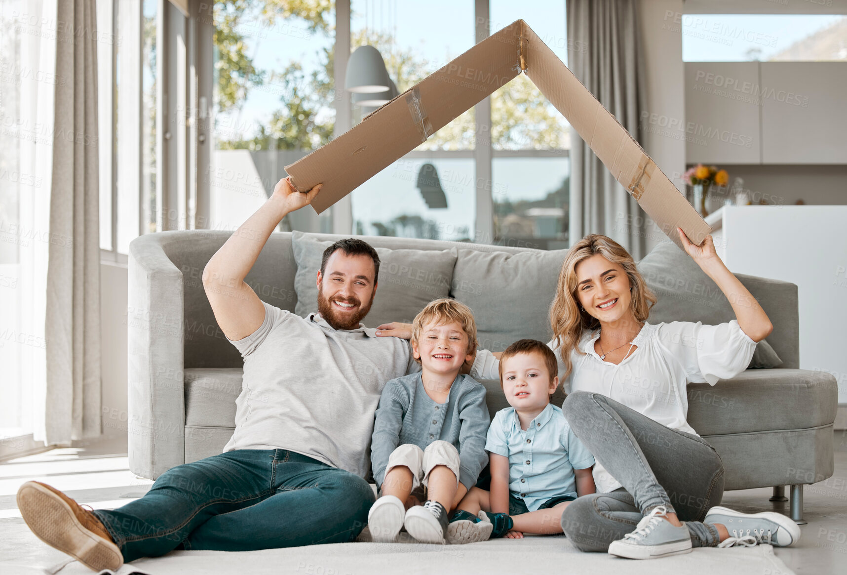 Buy stock photo Cardboard, roof and portrait of family for insurance, support and happy for relax or security in home. Mom, dad or parents with kids or protection for new house, wellness and care or love in lounge