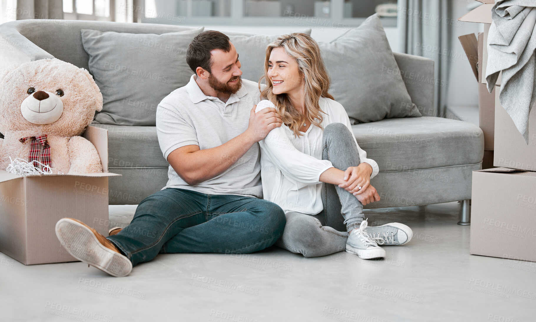 Buy stock photo Couple, love and smile with boxes, clothes and teddy bear for moving, celebration and new home. People, cardboard and happiness for real estate, apartment and property with investment on floor