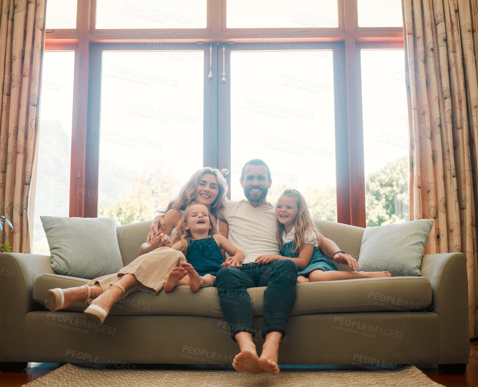 Buy stock photo Young happy content caucasian family holding a cardboard as a roof covering them sitting on the floor at home. Cheerful little girls bonding with their mother and father. Loving parents spending time with their cute daughters