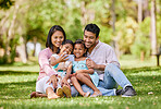 Happy asian family taking selfies on a cellphone in a park. Adorable little girls bonding with their parents outside. Full length husband and wife sitting and enjoying free time with their daughters