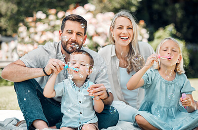 Buy stock photo Happy, family and blowing bubbles in garden or park with fun, bonding and support with care. Parents, kids and smile or laugh for child development or growth in outdoor with love and learning