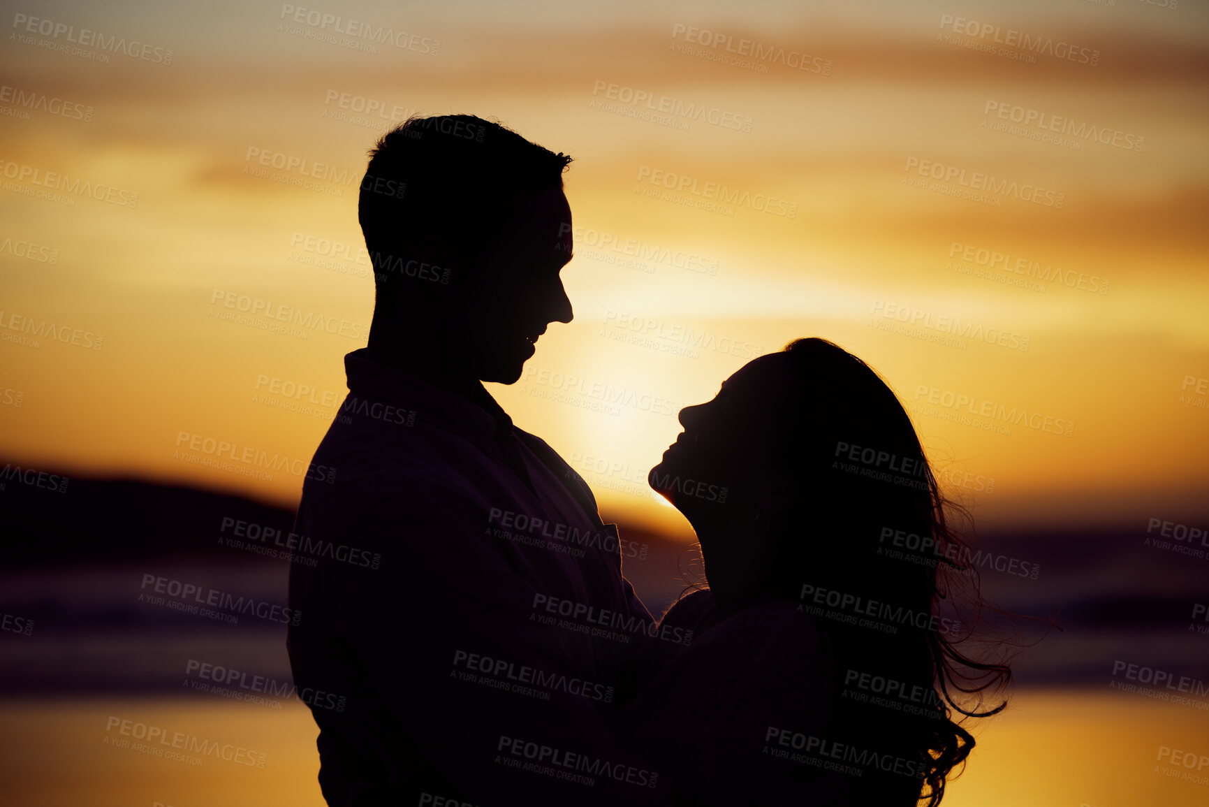 Buy stock photo Sunset, silhouette or couple on beach for hug, love or romance on honeymoon. Man, woman or travel in nature with embrace, trust or commitment in relationship on holiday for milestone or celebration