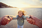 Father and daughter having fun at the beach. Daddy spinning little girl around by the arms by the sea at sunset. It's important to spend enough time with your children