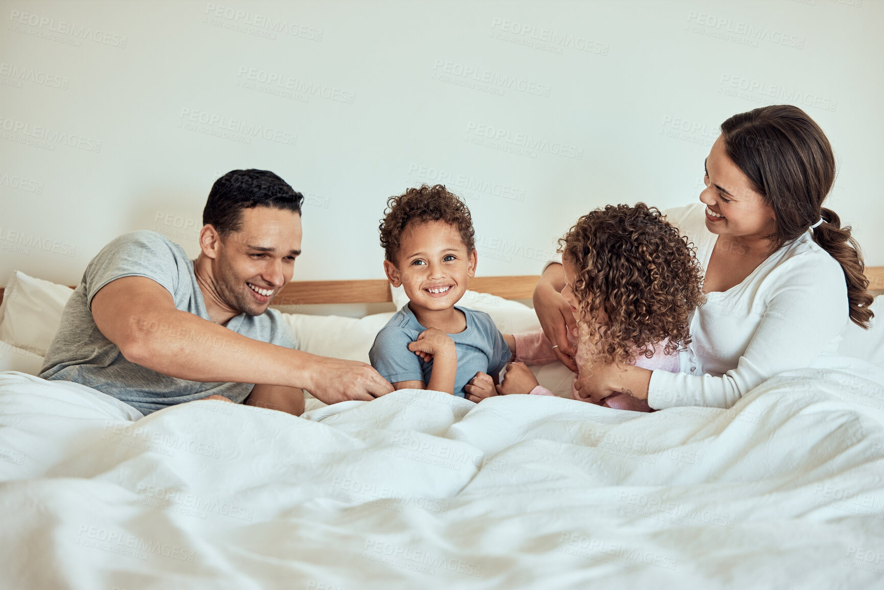 Buy stock photo Happy, family home and bed with children and parents together with laugh, game and playing in the morning. Funny, smile and bonding with love, care and support with mom and dad in bedroom with kids