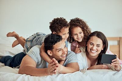 Buy stock photo Family, excited and happy on bed for selfie, relationship development and weekend fun at home. Parents, kids or love in bedroom for photography, good memories or domestic life blog update on internet