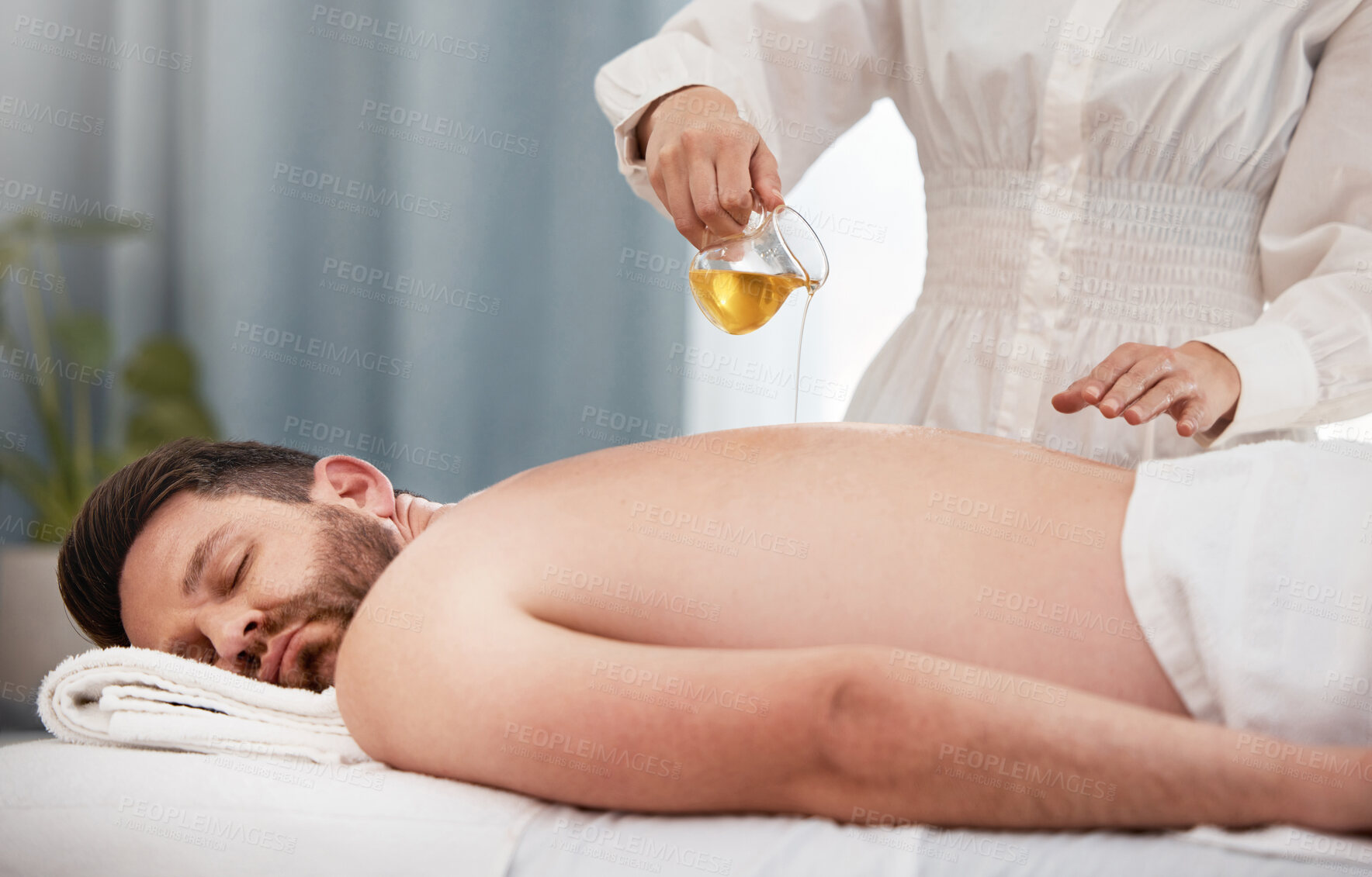 Buy stock photo Relax, spa and man with back massage, oil and therapist for wellness with luxury holistic treatment. Self care, masseuse and client on bed for body health, muscle care and peace with hotel service