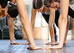 Closeup of diverse group of fit people doing bodyweight push up exercises while training together in a gym. Athletes doing press ups and plank hold to build muscle, enhance upper body, strengthen core and increase endurance for workout in fitness class