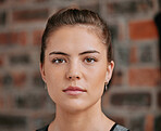 Closeup portrait of one serious woman alone in gym. Headshot of beautiful focused caucasian trainer standing after workout in health club. Young coach in fitness centre for routine exercise training