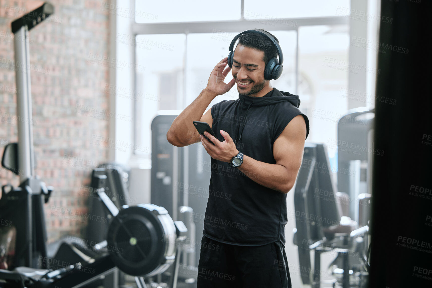 Buy stock photo Listening, headphones and man with cellphone in gym, athlete and ready for workout, fitness and training. Health club, guy and routine of exercise in morning, ambition and preparing of competition