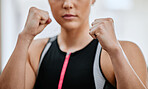 Closeup of unknown serious trainer in boxing stance alone in gym. Focused caucasian coach ready to fight in self defence in health club workout. Kickboxing woman in fitness centre in training exercise