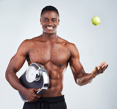 Buy stock photo Apple, scale and portrait of black man in studio for diet, health and wellness for gym balance with nutrition. Muscles, snack and African person with organic fruit for vitamins by white background.