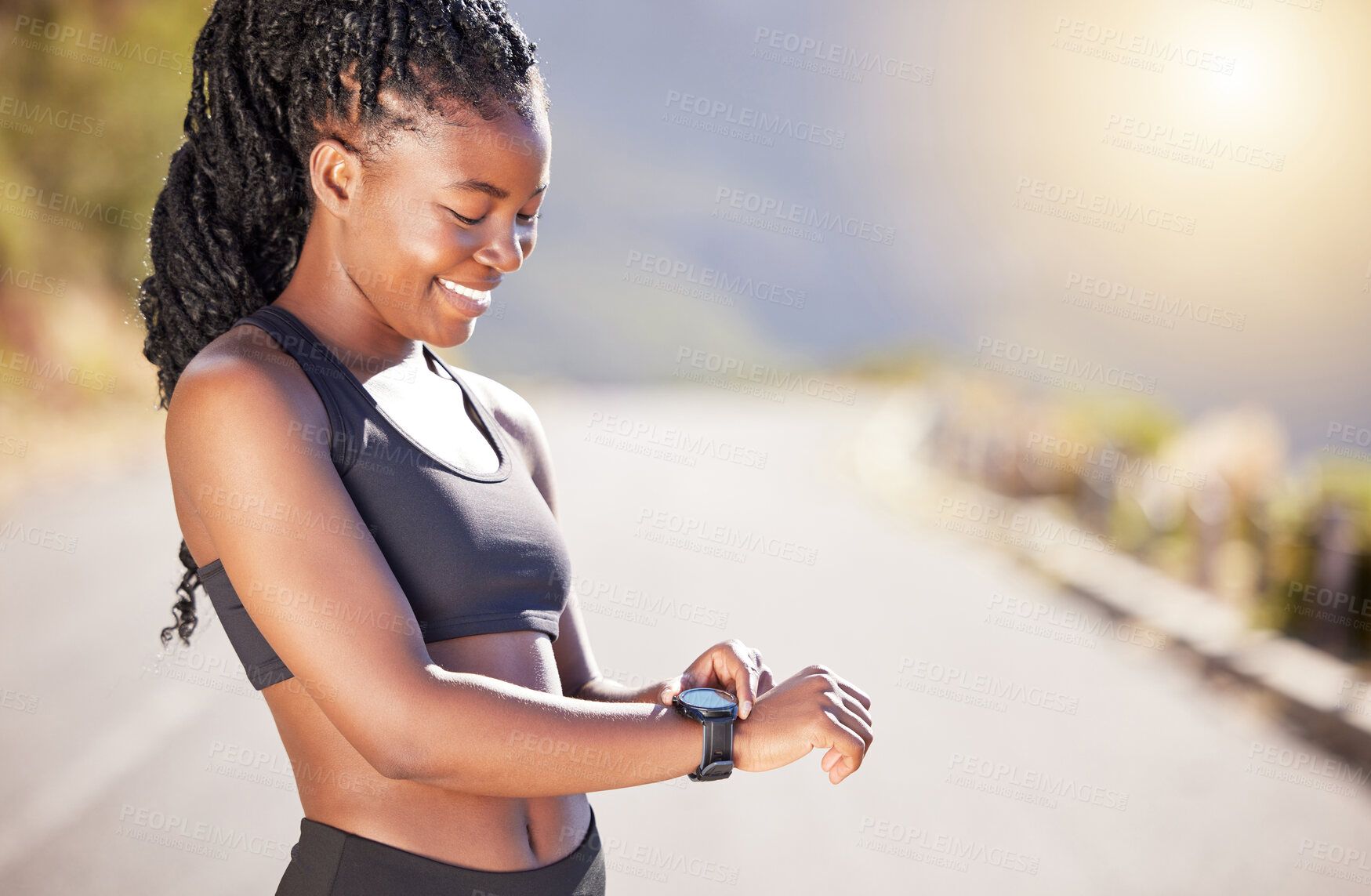 Buy stock photo Happy black woman, runner and checking with watch for fitness, performance or tracking on mountain road. Young African, female person or athlete with smile for wristwatch, workout or outdoor exercise