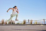 Active mixed race young woman running for exercise outdoors. Athlete jogging for a refreshing cardio training workout in the morning. Determined to build endurance to reach fitness and wellness goals