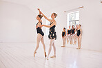 Young woman dance instructor teaching a ballet class to a group of a children in her studio. Ballerina teacher working with girl students, preparing for their recital, performance or upcoming show