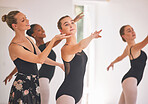 Young woman dance instructor teaching a ballet class to a group of a children in her studio. Ballerina teacher working with girl students, preparing for their recital, performance or upcoming show