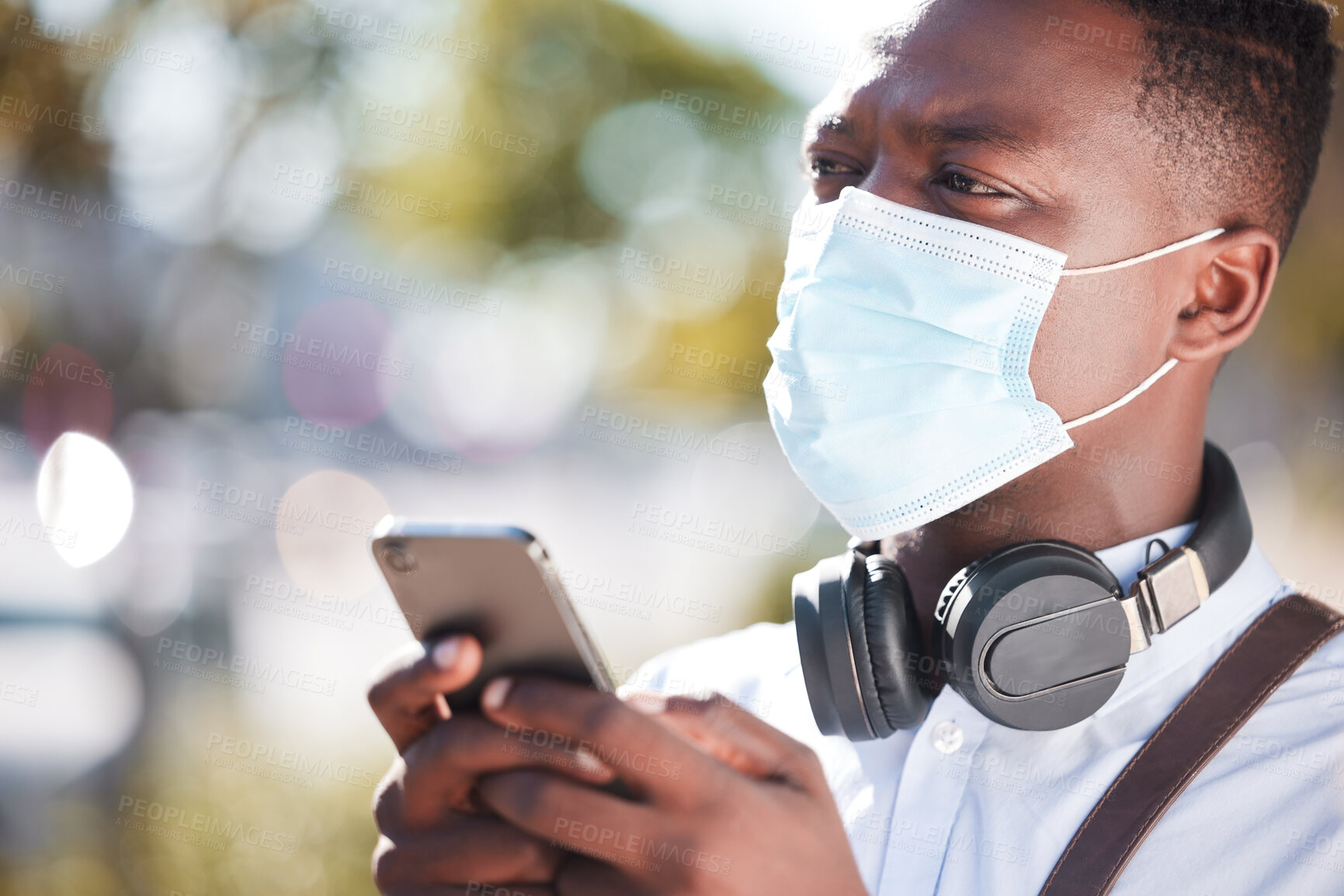 Buy stock photo Black man, phone and face mask in outdoor for networking, virus pandemic and online for conversation. Male person, employee and travel in city for commute, app and email business contact on sidewalk
