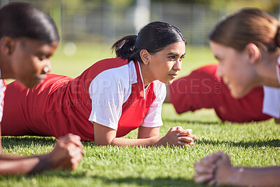 Buy stock photo Women soccer players in a team doing the plank fitness exercise in training together on a practice sports field. Healthy female group of young athletes doing a core strength workout using teamwork 