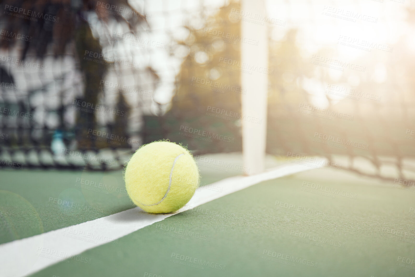 Buy stock photo Tennis, practice and court with ball by net for sports match, tournament and outdoors at sunset. Green, sphere and stadium with equipment on ground for game, activity and competition in Paris