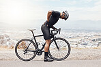 Full body of fit and active indian man standing alone and suffering from backache while cycling during his workout outside. Mixed race athlete holding his back in pain after an injury during exercise