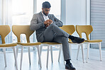 Young indian businessman wearing suit checking the time on his watch while sitting and waiting in line on a chair for interview. Guy getting impatient for job vacancy meeting. Punctuality is important