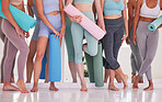 Feet of women in yoga class. group of women standing in a yoga studio. Friends bonding before class cropped. Group of women holding yoga exercise mats in a class. Sporty women being social