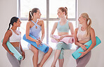 Happy women bonding before yoga class. Group of friends holding yoga mats before class. Friends ready for a holistic yoga practice. Women talking before yoga exercise practice