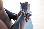 Above one muscular african american man holding his wrist in pain while exercising outdoors. Closeup of male athlete suffering with a sore arm injury. Could be muscular or joint pain and discomfort