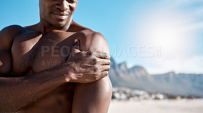 Buy stock photo Exercise, shoulder pain and man on beach with injury for arm inflammation, muscle strain or ache. Outdoor, body and black person with discomfort for sprain, workout accident or outdoor emergency