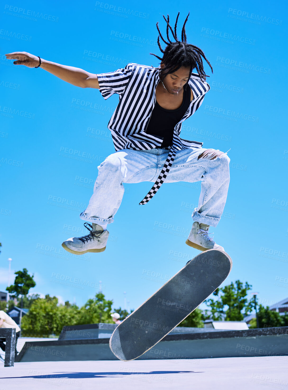 Buy stock photo Skateboard, park and black man with jump in air for fun trick, practice and energy in summer. Blue sky, skater and male person with ollie flip on concrete for outdoor hobby, competition and talent