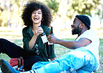 Wine bottle, celebration and couple having a picnic date at the park or on a field with nature bokeh. Young and excited black man and woman or people with alcohol drink and enjoying outdoor together