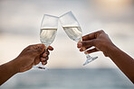 African american couple drinking champagne at the sea together. Caring boyfriend and girlfriend spending a day on the beach. Husband and wife toasting on the beach