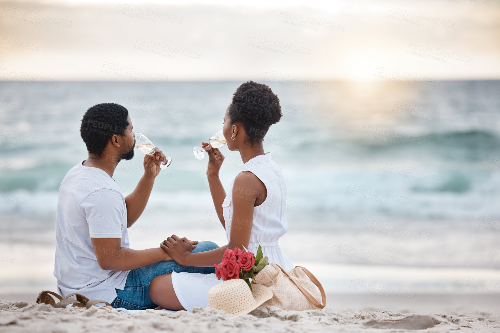 Buy stock photo Black couple, drink and relax outdoor by beach for romantic date on vacation, anniversary getaway and bonding. Man, woman and together with white wine, ocean escape and commitment for love connection