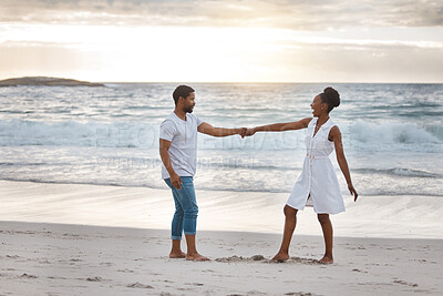 Buy stock photo Couple, dance and sunset at beach for holiday, travel and date in summer while bonding together. Man, woman and holding hands by ocean for vacation, love and freedom with romance, water and sand