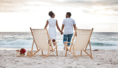 Buy stock photo Sunset, black couple and break with beach chair, holding hands or celebrating for anniversary. Vacation, picnic and people travel for marriage on honeymoon, summer holiday and happy bonding in Miami