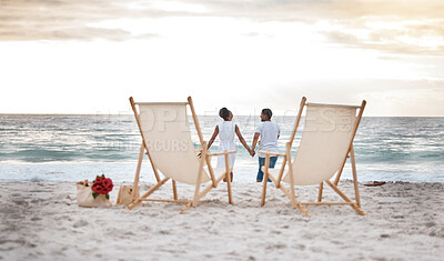 Buy stock photo Sunset, black couple and waves with beach chair, holding hands or celebrating for anniversary. Vacation, picnic and people travel for marriage on honeymoon, summer holiday and happy bonding in Miami