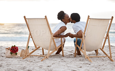 Buy stock photo Sunset, black couple and kiss with beach chair, holding hands or celebrating for anniversary. Vacation, picnic and people travel for marriage on honeymoon, summer holiday and happy bonding in Miami