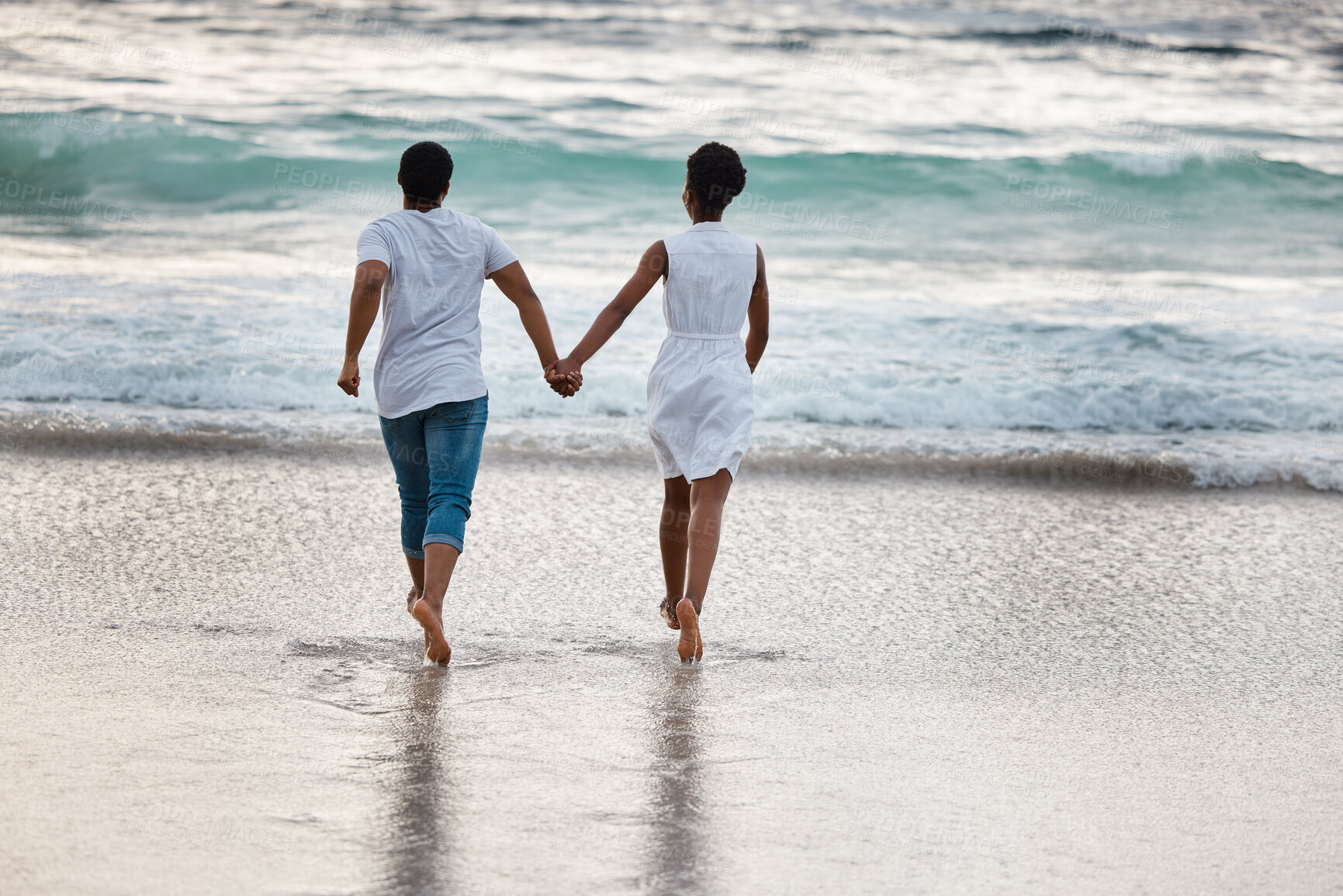 Buy stock photo Sunset, black couple and waves with splash, holding hands or celebrating for anniversary. Vacation, play and people travel for marriage on honeymoon, summer holiday and happy bonding in Miami