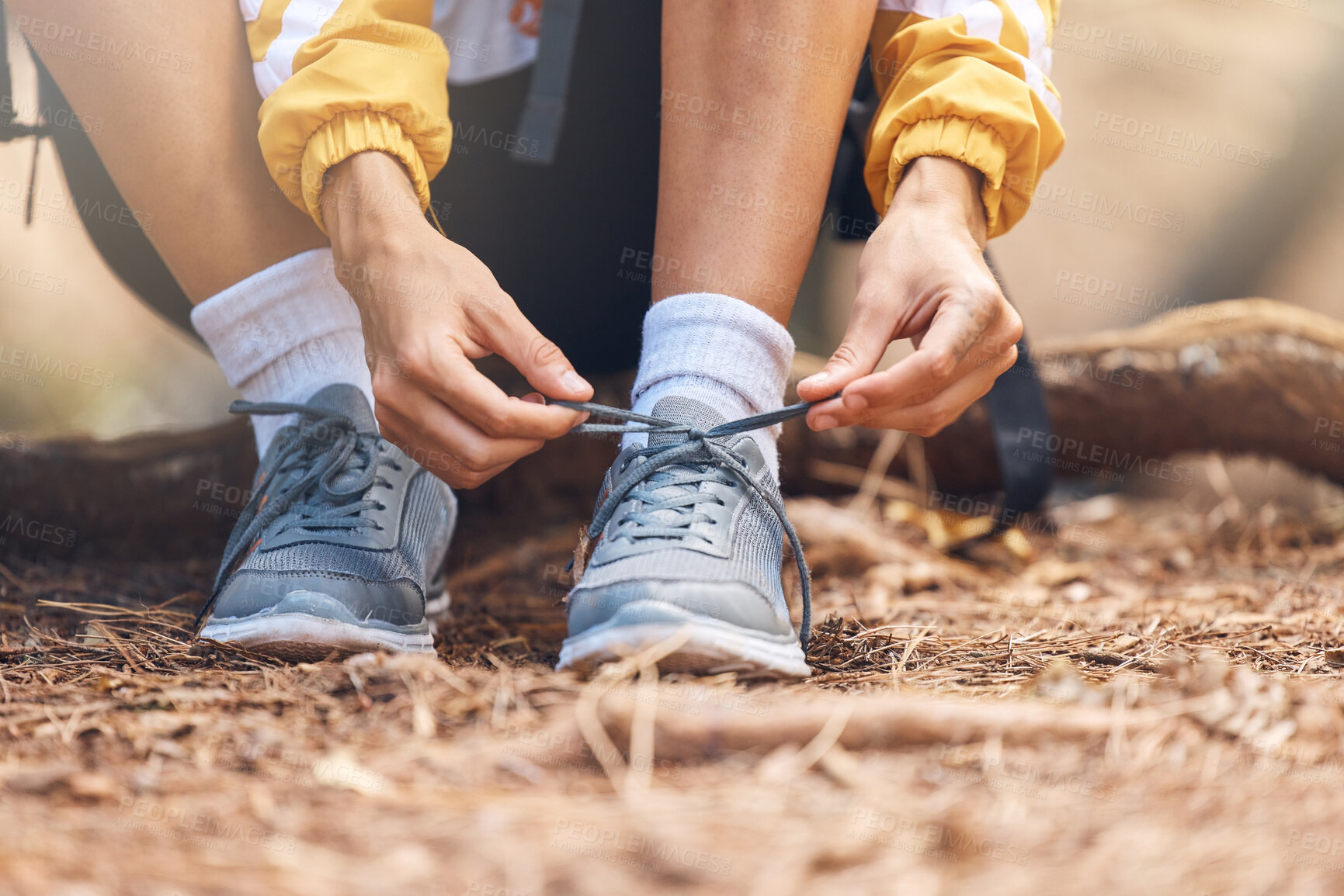 Buy stock photo Hands, tie and sneakers for hiking outdoor for fitness travel, exercise and walking in forest for adventure. Active, person and shoes on ground, backpack and trekking journey with feet support