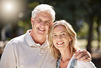 Portrait of an attractive young woman and her father outdoors. Young caucasian female and her senior father bonding outside in the garden on a sunny day