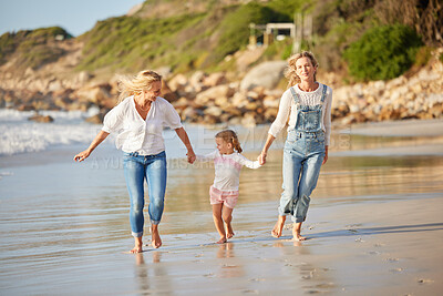 Buy stock photo Lesbian, mother and child with vacation at beach for outdoor adventure, love or summer holiday. Happy, LGBTQ women and holding hands with daughter by ocean water for running, care or travel in Cancun