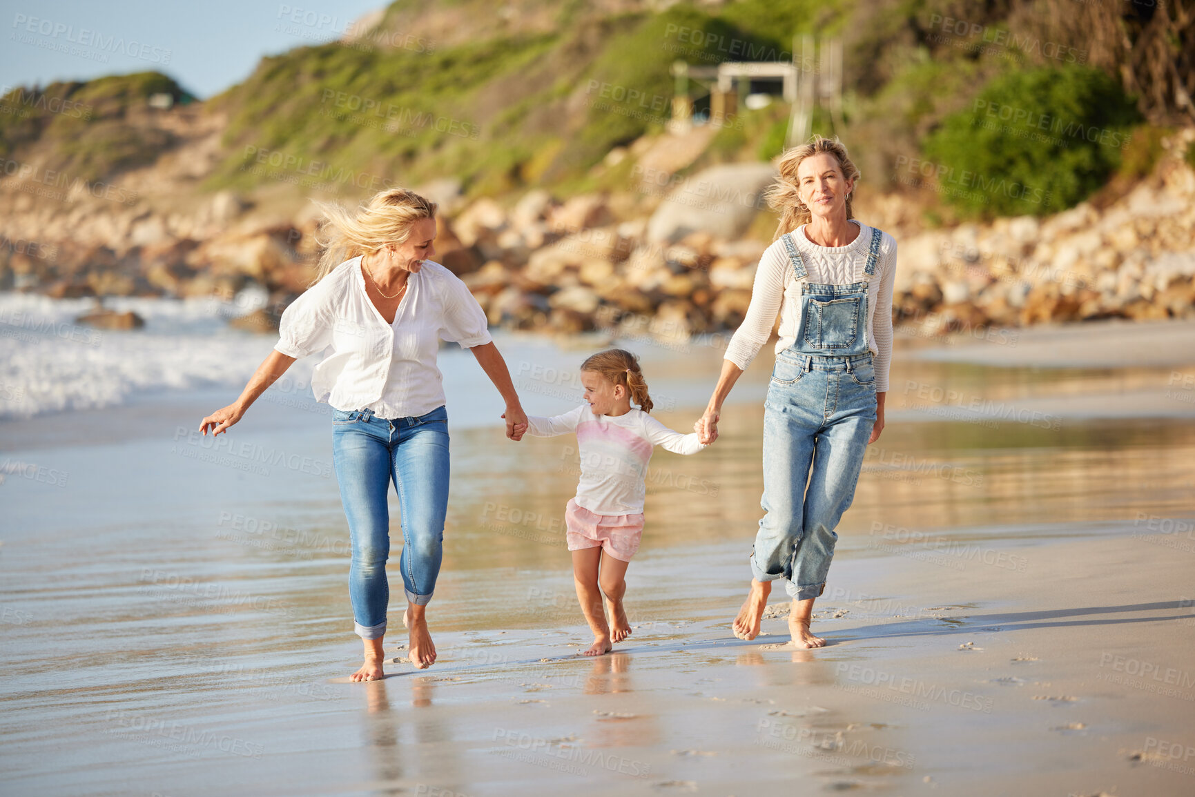 Buy stock photo Lesbian, mother and child with vacation at beach for outdoor adventure, love or summer holiday. Happy, LGBTQ women and holding hands with daughter by ocean water for running, care or travel in Cancun