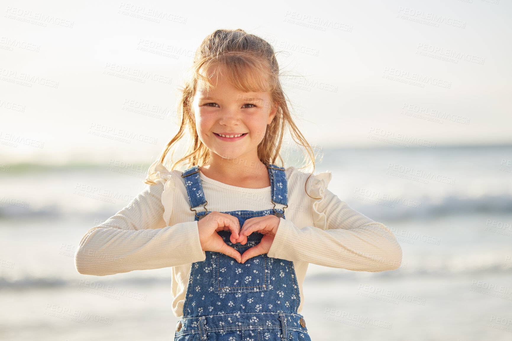 Buy stock photo Beach, portrait and child with hands for heart shape on summer vacation, adventure or holiday. Smile, travel and girl by tropical ocean with love emoji, sign or gesture for weekend trip in Australia.