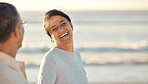 A senior mixed race couple walking together on the beach  smiling and laughing on a day out at the beach. Hispanic husband and wife looking happy and showing affection while having a romantic day on the beach