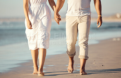 Buy stock photo Couple, walking and holding hands on beach with love for travel journey, care and bonding on marriage date by ocean. Feet, woman and man with support, trust and morning on vacation for peace outdoor