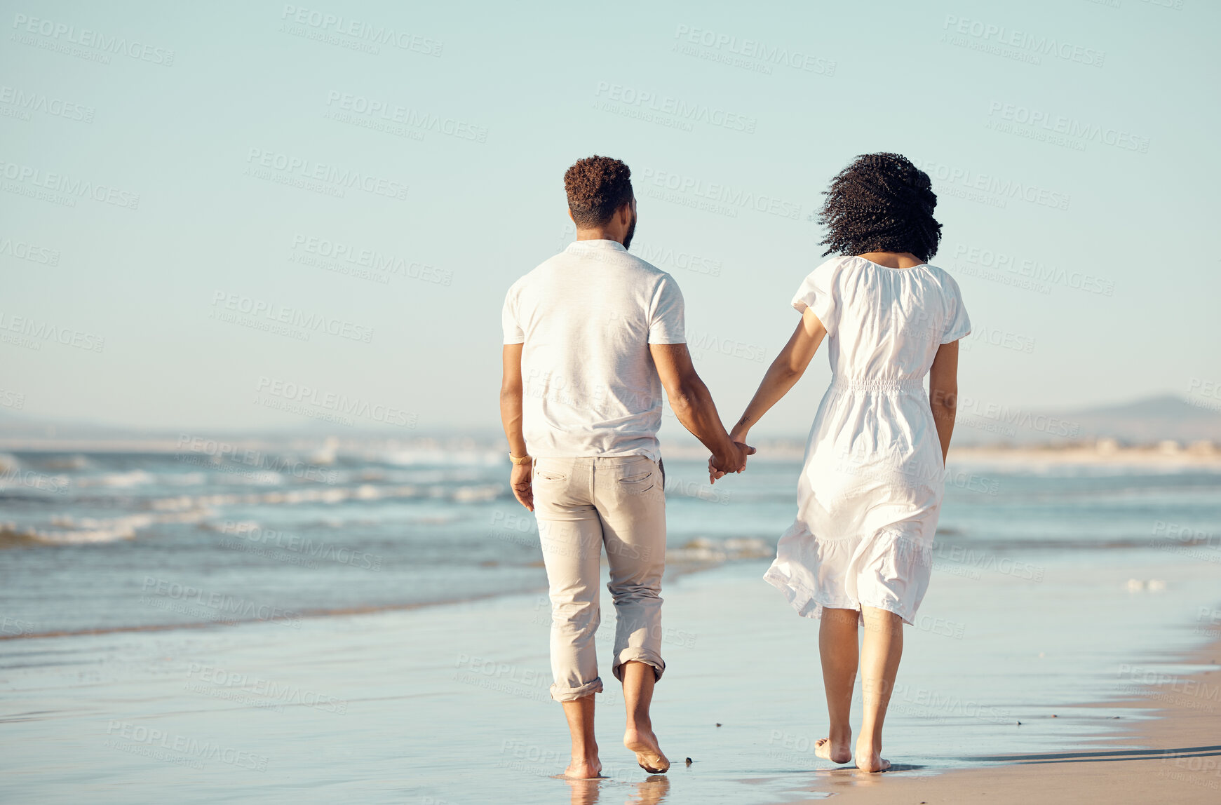 Buy stock photo Couple, holding hands and walking on beach with love for travel journey, care and bonding on marriage date by ocean. Back, woman and man with support, trust and morning on vacation for peace outdoor