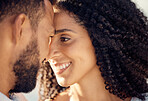 Closeup of an young affectionate mixed race couple standing on the beach and smiling during sunset outdoors. Hispanic couple showing love and affection on a romantic date at the beach