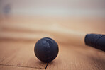 Closeup of squash equipment and gear on wooden floor in empty court in sports centre with copyspace. Two rackets and ball arranged in sporty arena with nobody before championship game and competition