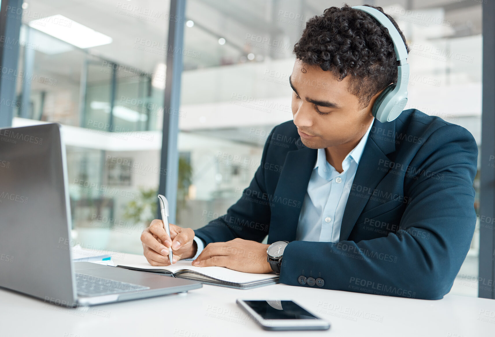 Buy stock photo Writing, businessman and headphones with laptop in office for research, planning and project. Financial advisor, notebook and news at desk for career, online for music or podcast in workplace